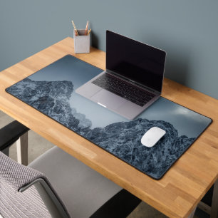 Sunlight and dark clouds over snowy mountains desk mat