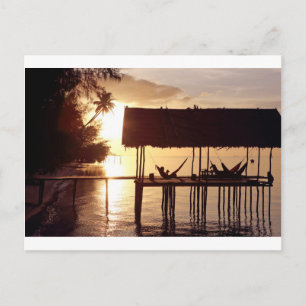 Sunset in hammock on tropical island beach postcard