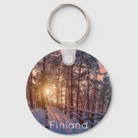 Sunset in snowy pine forest with sun ray