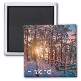 Sunset in snowy pine forest with sun ray magnet