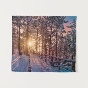 Sunset in snowy pine forest with sun ray tapestry