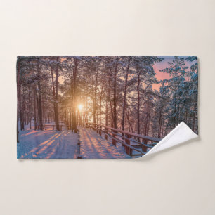 Sunset in snowy pine forest with sun ray Towel