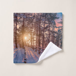 Sunset in snowy pine forest with sun ray wash cloth