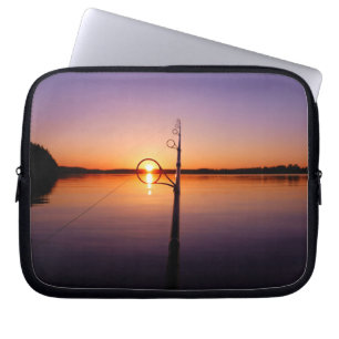 Sunset on a summer lake seen through a fishing rod laptop sleeve