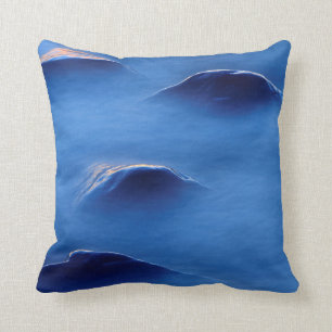 Sunset on rocks protruding through foamy water cushion