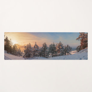Sunset over frozen snowy forest near sea yoga mat