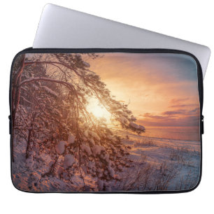 Sunset over sea and snowy pine tree laptop sleeve