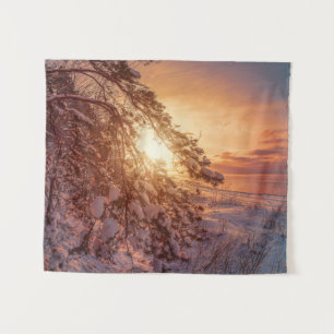 Sunset over sea and snowy pine tree tapestry