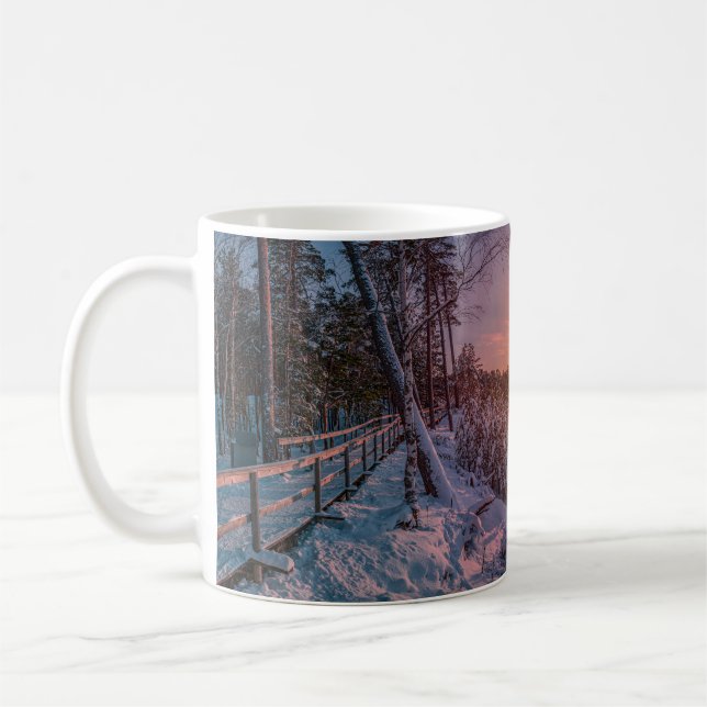 Sunset over snow sea coast coffee mug (Left)