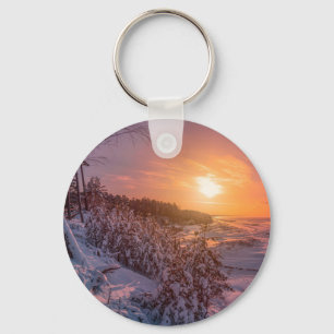 Sunset over snow sea coast key ring
