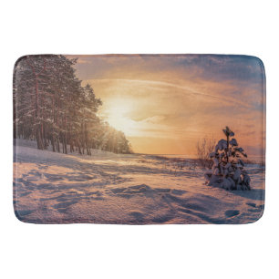 Sunset over snowy winter sea coast bath mat