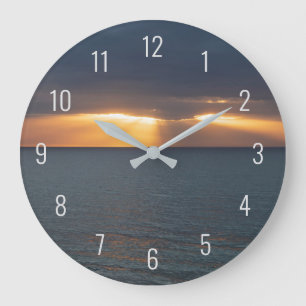 Sunset over the ocean breaking through the clouds large clock