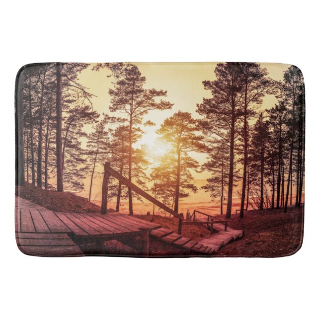 Sunset over wooden path in pine forest bath mat (Front)