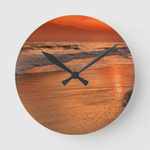 Sunset reflections off clouds and ocean shore round clock