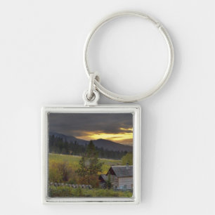 Sunset sky over vineyards and historic log cabin key ring
