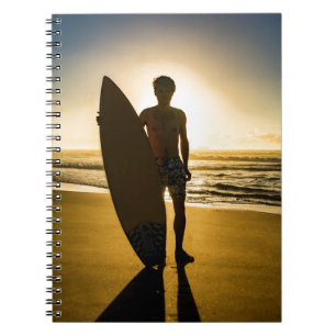 Surfer silhouette during sunrise notebook