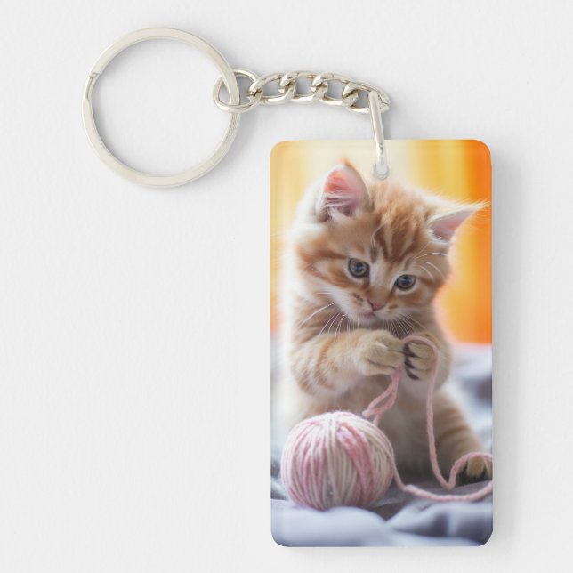 Sweet orange kitten playing with yarn key ring (Front)
