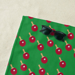 Table tennis racket and ball on green beach towel