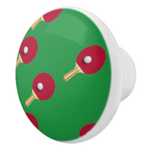 Table tennis racket and ball on green ceramic knob