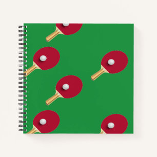 Table tennis racket and ball on green notebook
