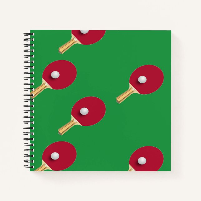 Table tennis racket and ball on green notebook (Front)