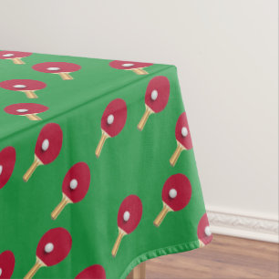 Table tennis racket and ball on green tablecloth