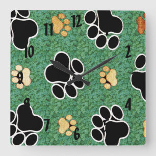 Tan and black paw print on green grass square wall clock