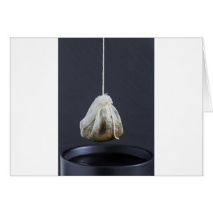Tea bag is hung in a cup