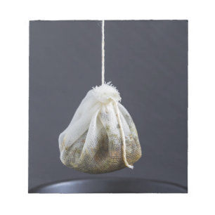 Tea bag is hung in a cup notepad