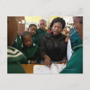 Teacher assists a group of learner's in the postcard