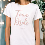 Team Bride Wedding Personalised Dusty Pink White T-Shirt<br><div class="desc">Celebrate your bride squad with this personalised wedding t-shirt! The words 'Team Bride' are written in a trendy script font, and below you can add a custom name, wedding date, location or other text. A lovely gift for a bachelorette party, wedding shower or celebration weekend! Colours: dusty pink and white....</div>