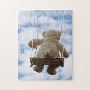 Teddy bear on a swing with a cloudy blue sky. jigsaw puzzle