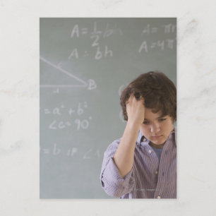 Teenaged boy in front of blackboard with math postcard