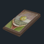 Tennis Racket with Ball Laying on Court Tri-fold Wallet<br><div class="desc">Enjoy a little tennis with this scene painted by Ethan Harper. A well stitched racket with a ball sitting on the middle,  you just want to pick it up,  head to your local court and play a game. Purchase your copy of this print today!</div>
