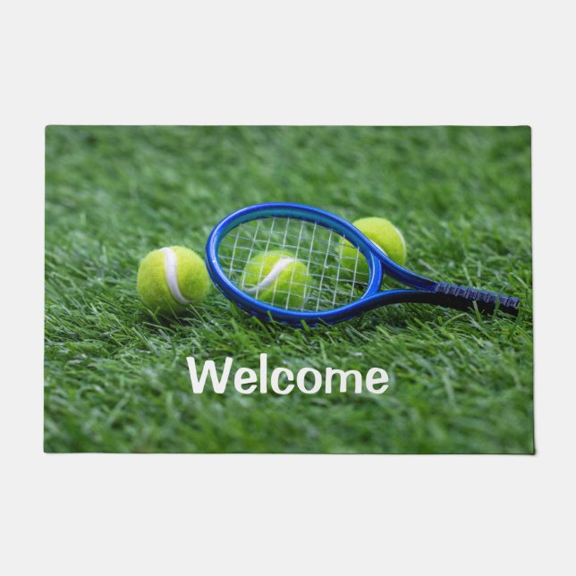 Tennis racket with ball on green grass doormat (Front)