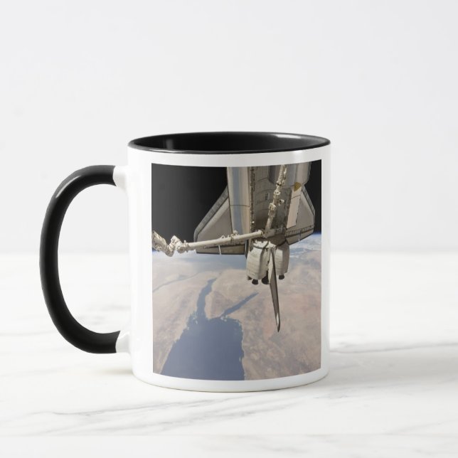 The aft section of the docked space shuttle mug (Left)