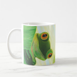 The big-eyed green frog behind lily pad coffee mug