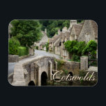 The bridge in Castle Combe, UK text magnet<br><div class="desc">Rectangular magnet of the bridge over Bybrook River in the small,  quaint village of Castle Combe with houses built out of honey-coloured stone in the Cotswolds,  England,  UK with the text: 'Cotswolds'. A great souvenir!</div>
