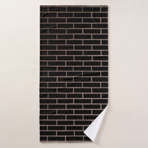 The dark black brick wall has a rough surface as a bath towel