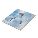 The Dreams Of Dolphins Tile<br><div class="desc">A dolphin jumps out of the waterhole into the ocean. This dolphin is expected from two other dolphins. Click on Customise to personalised the gift product!</div>