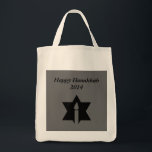 The Flame & Star - Tote Bag<br><div class="desc">This image is a flame from a candle. A star around the flame represents Hanukkah. Done in a black tattoo. A black backround was also added. "Happy Hanukkah 2014" is printed on this design. Customise with your own words. These totes are available in assorted styles,  colours and sizes.</div>