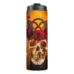 The human skull on the black table lies in the ros thermal tumbler