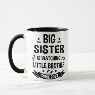 The little sister takes care of the big brother in mug