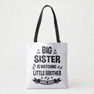 The little sister takes care of the big brother in tote bag