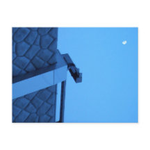 The moon hangs above the breakwater.