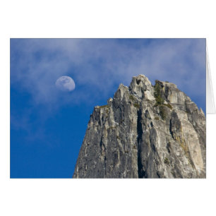 The moon rises and shines through the clouds