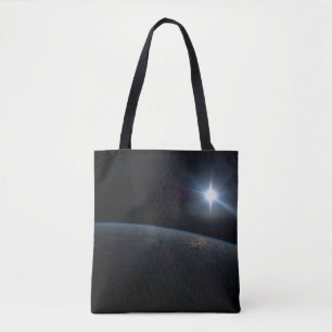 The Sun Setting Over Earth's Horizon. Tote Bag