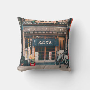 THREE BICYCLES PARKED IN FRONT OF BUILDING CUSHION