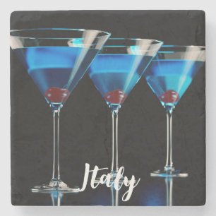 Three blue cocktails with cherry on black stone coaster