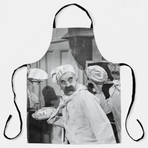Three chefs holding pies for a fight in the kitche apron
